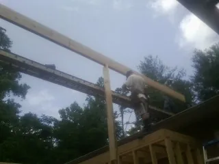 Carpenter setting a ridge beam over a new addition frame — Ice Dam Removal by Roofing Brothers in Menlo Park