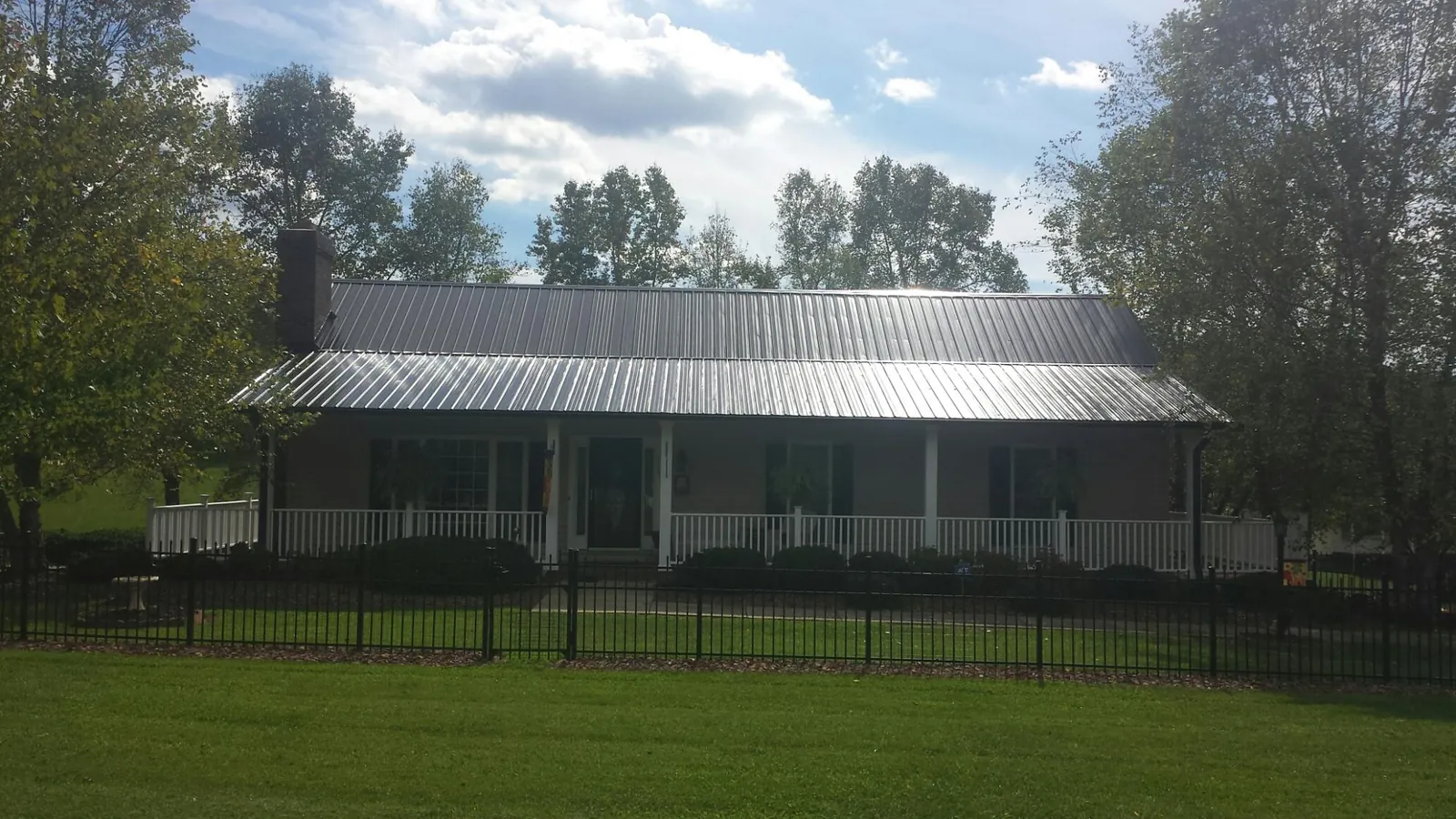 Gray metal roof on a brick ranch with a full width front porch — Gutter Guard Installation work by our crew in Menlo Park